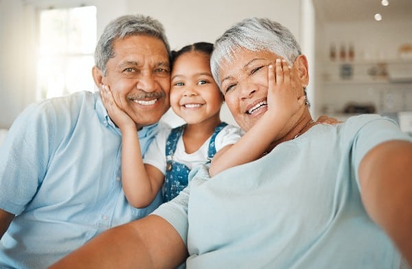 Une fille souriante avec ses grands-parents