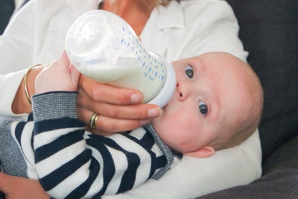 un bébé qui bois dans son biberon